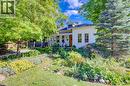White exterior with a prominent wooden front door, multiple windows, and a dormer - 59 Allen Street W, Waterloo, ON 
