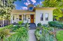 Welcoming front porch, manicured landscaping, light-colored exterior, natural wood-finish front door, and a prominent dormer window - 59 Allen Street W, Waterloo, ON 
