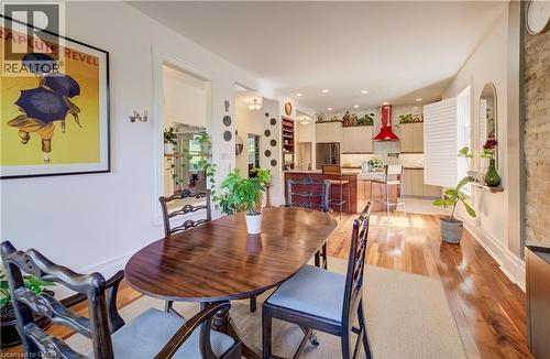 Hardwood flooring throughout, recessed lighting, exposed brick wall, built-in shelving, and a kitchen featuring a red range hood - 59 Allen Street W, Waterloo, ON 
