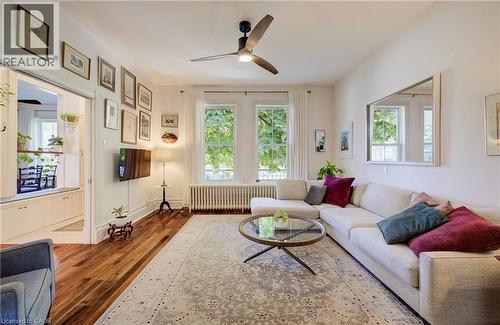 Wood-finish flooring with a ceiling fan, dual window exposures, and a built-in storage unit - 59 Allen Street W, Waterloo, ON 