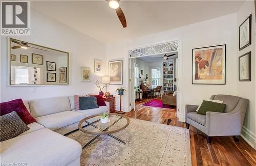 Hardwood flooring, cased opening with transom detail, ceiling fan with light, recessed lighting, and white baseboards - 59 Allen Street W, Waterloo, ON 