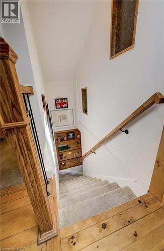 Hardwood flooring with a natural finish, carpeted stairs, and a wooden handrail - 59 Allen Street W, Waterloo, ON 