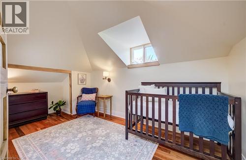 Attic room featuring a sloped ceiling, wood-finish flooring, and a dormer window - 59 Allen Street W, Waterloo, ON 