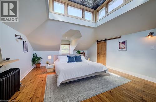 Hardwood flooring, wood-framed windows, exposed wood ceiling, and a sliding barn door - 59 Allen Street W, Waterloo, ON 