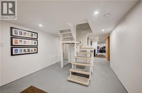 White painted walls, recessed lighting, and gray-painted concrete flooring - 59 Allen Street W, Waterloo, ON 