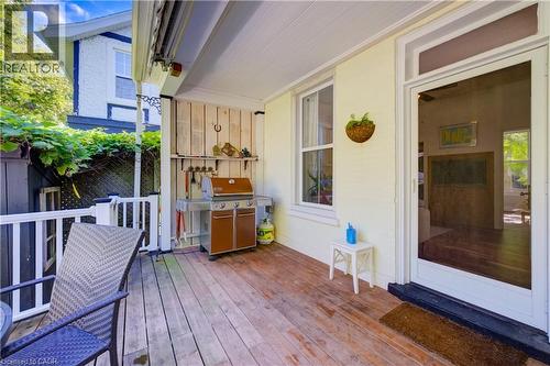 Covered outdoor porch with wood-plank flooring, white railing, and exterior wall paneling - 59 Allen Street W, Waterloo, ON 