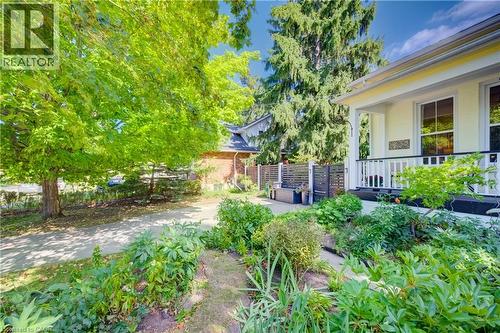 Light-colored exterior with a front porch featuring white railings - 59 Allen Street W, Waterloo, ON 