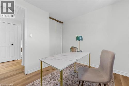 Bright room featuring wood-finish flooring, white baseboards, and a neutral wall color - 49 Grove Avenue, St. Catharines, ON 