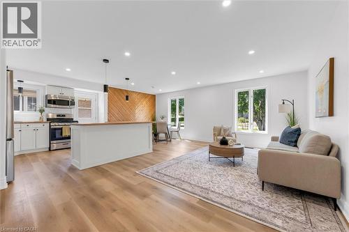 Open-concept living space featuring wood-finish flooring throughout, recessed lighting, and a white color palette - 49 Grove Avenue, St. Catharines, ON 