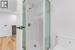 Enclosed corner shower with glass surround, white shower base, and integrated shelving - 