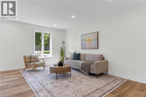 Spacious living area featuring light wood-finish flooring, white baseboards, and recessed lighting - 49 Grove Avenue, St. Catharines, ON 