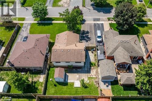 Aerial perspective showcasing three residential properties with brown shingle roofing - 49 Grove Avenue, St. Catharines, ON 