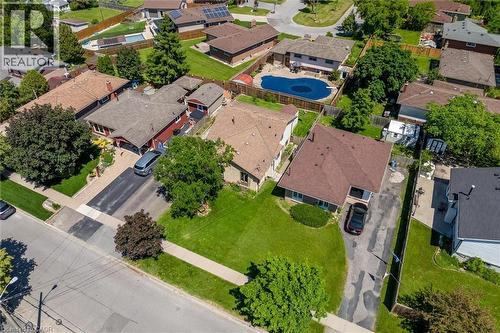 Expansive suburban property featuring a large manicured lawn, paved driveway, mature trees, and a brown shingle roof - 49 Grove Avenue, St. Catharines, ON 