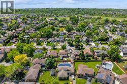 Aerial perspective of a residential neighborhood featuring established homes and abundant mature trees - 