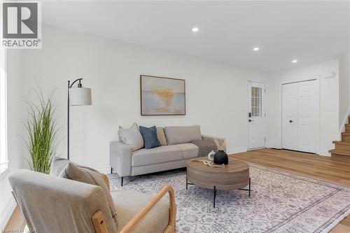 Open-concept living space featuring light-toned walls, recessed lighting, and wood-finish flooring - 49 Grove Avenue, St. Catharines, ON 