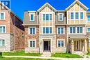 Three-story townhome featuring a stone and brick exterior, multi-pane windows, and a prominent front entrance - 212 Ellen Davidson Drive, Oakville, ON 