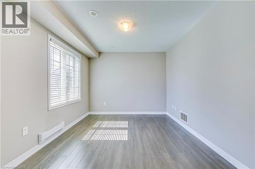 Wood-finish flooring with white trim, a window with blinds, and recessed lighting - 212 Ellen Davidson Drive, Oakville, ON 