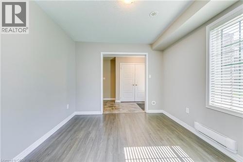 Wood-finish flooring, white trim, and a window with blinds - 212 Ellen Davidson Drive, Oakville, ON 