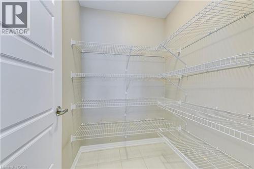 Integrated wire shelving system, tiled flooring, and a paneled door with a brushed metal handle - 212 Ellen Davidson Drive, Oakville, ON 
