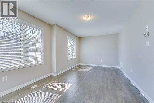 Wood-finish flooring, multiple windows with blinds, ceiling-mounted light fixture, and neutral wall tones - 212 Ellen Davidson Drive, Oakville, ON 