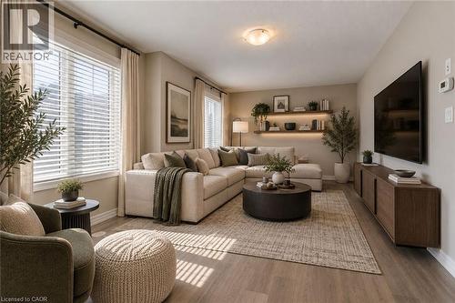 Wood-finish flooring, recessed lighting, built-in floating shelving with integrated lighting, and dual large windows with blinds - 212 Ellen Davidson Drive, Oakville, ON 