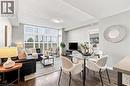 Wood-finish flooring throughout, a wall of windows with plantation shutters, recessed and flush-mount ceiling lighting, and light gray wall paint - 427 Aberdeen Avenue Unit# 105, Hamilton, ON 