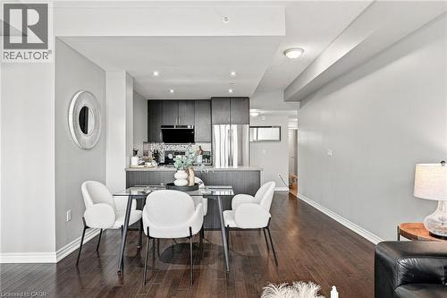 Open-concept living area featuring wood-finish flooring, recessed lighting, and a kitchen with dark cabinetry and stainless steel appliances - 427 Aberdeen Avenue Unit# 105, Hamilton, ON 