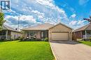 Brick exterior with an attached garage, paved driveway, and covered front porch - 915 St George Street, Port Dover, ON 