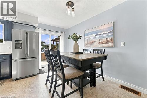 Stainless steel refrigerator, built-in cabinetry, tiled flooring, overhead lighting, and sliding glass door - 915 St George Street, Port Dover, ON 