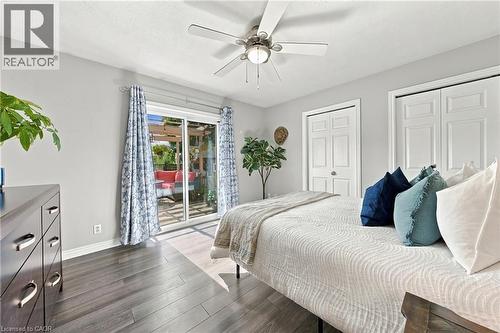 Sliding glass door, wood-finish flooring, ceiling fan with integrated lighting, and white bi-fold closet doors - 915 St George Street, Port Dover, ON 