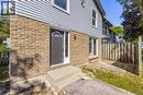 Brick and siding exterior with a dark-paneled entry door, arched transom window, and exterior light fixture - 70 Fiddlers Green Road Unit# 74, London, ON 