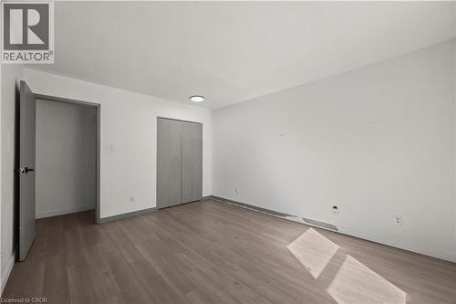Wood-finish flooring with a neutral white wall finish and gray trim - 70 Fiddlers Green Road Unit# 74, London, ON 
