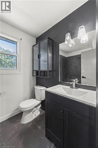 Vanity with white integrated sink, chrome faucet, and dark cabinet - 70 Fiddlers Green Road Unit# 74, London, ON 