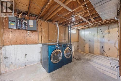 Unfinished basement area featuring a concrete floor, exposed wood ceiling joists, and a visible electrical panel - 70 Fiddlers Green Road Unit# 74, London, ON 