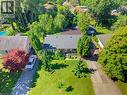 Exterior featuring a dark shingle roof, established landscaping, and a paved driveway - 940 Harvey Place, Halton, ON 