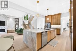 Kitchen island with integrated sink, stainless steel dishwasher, and quartz countertop - 
