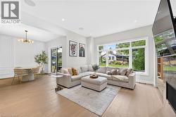 Recessed lighting, wood-finish flooring, large picture window, glass sliding door, and wall paneling - 
