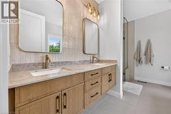 Dual vanity with natural wood-finish cabinetry and bronze-finish hardware - 
