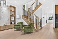 Hardwood flooring, custom built-in cabinetry, large format wall paneling, open-tread staircase with black iron spindles, recessed lighting - 