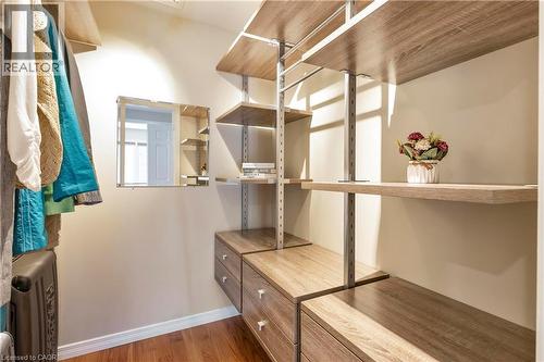 Custom closet system featuring wood-finish shelving, integrated drawers, and a built-in mirror - 475 Beechwood Drive Unit# 4, Waterloo, ON 