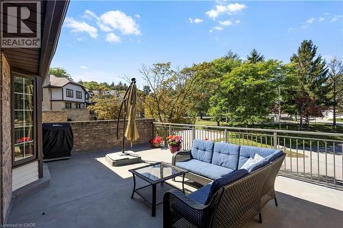 Spacious outdoor patio with a concrete surface, brick exterior wall, and metal railings - 475 Beechwood Drive Unit# 4, Waterloo, ON 