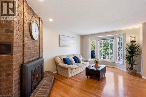 Brick fireplace with hearth, hardwood flooring, and a bay window - 475 Beechwood Drive Unit# 4, Waterloo, ON 