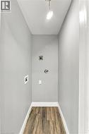Utility space featuring wood-finish flooring, dedicated appliance hookups, and recessed ceiling lighting - 