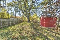Backyard featuring mature trees, a wooden privacy fence, and an exterior storage shed - 