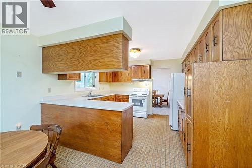 Kitchen with wood-finish cabinetry, white countertops, and patterned flooring - 12 Mullen Place, Glen Williams, ON 