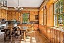 Wood-paneled walls and cabinetry, multiple windows with natural light, tiled flooring, and a built-in kitchen sink - 2744 Bleams Road, New Hamburg, ON 