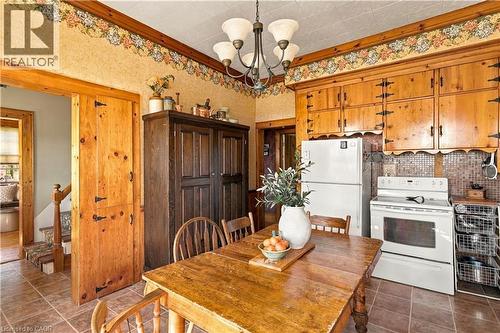 Kitchen featuring wood-finish cabinetry, tile flooring, and a tiled backsplash - 2744 Bleams Road, New Hamburg, ON 