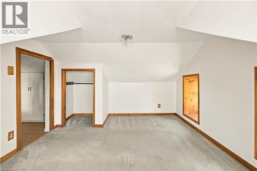 Carpeted room with a sloped ceiling, wood-finish trim, and a recessed wall niche - 2744 Bleams Road, New Hamburg, ON 