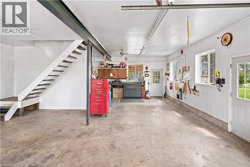 Concrete flooring with ample open space, multiple windows, and a built-in workbench with cabinetry - 2744 Bleams Road, New Hamburg, ON 