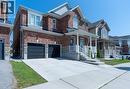 Brick exterior with stone accents, covered front porch, two-car garage, and concrete driveway - 455 Equestrian Way, Cambridge, ON 